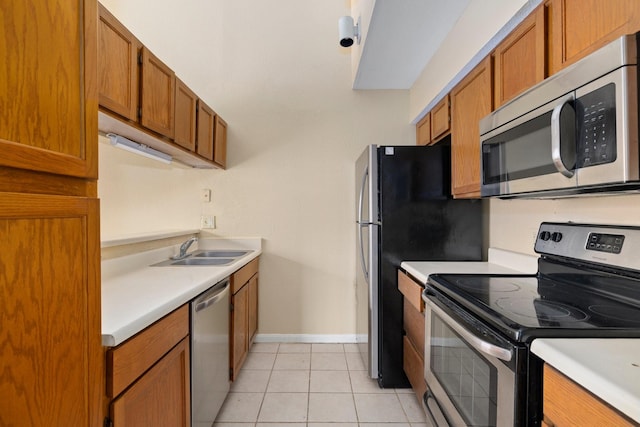 kitchen with sink, light tile patterned floors, and stainless steel appliances