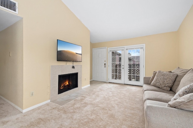 carpeted living room featuring a fireplace, french doors, and vaulted ceiling