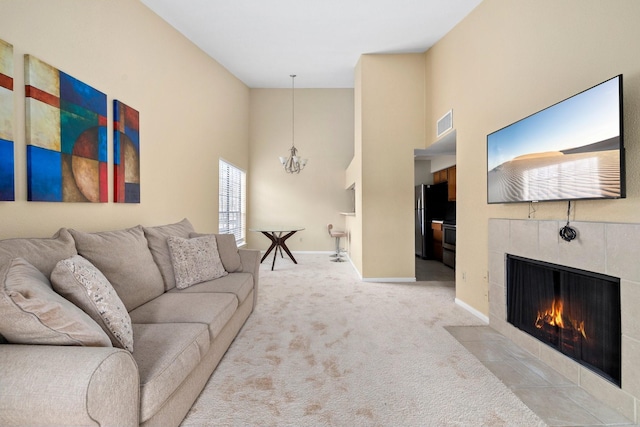 living room with a chandelier, light colored carpet, and a fireplace