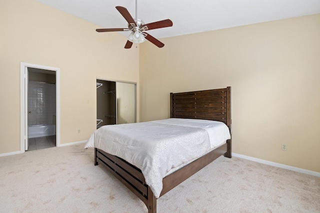 carpeted bedroom with connected bathroom, ceiling fan, and a closet