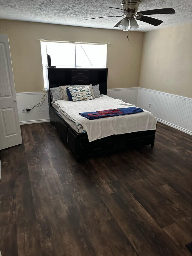 bedroom featuring a textured ceiling, ceiling fan, and dark wood-type flooring