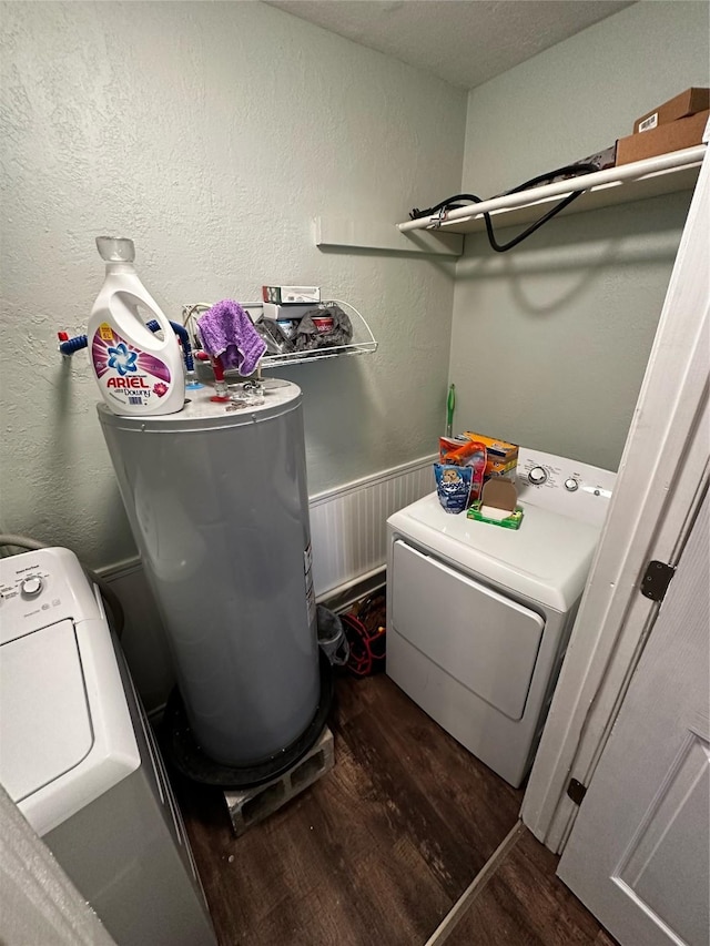 washroom with dark hardwood / wood-style flooring, washing machine and dryer, and water heater