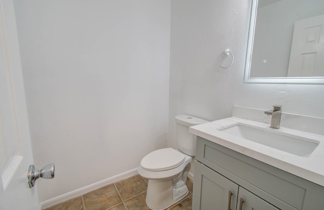 bathroom featuring tile patterned floors, vanity, and toilet