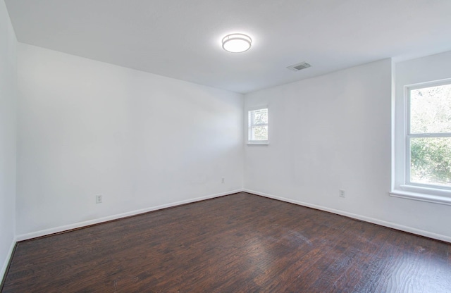 unfurnished room featuring dark hardwood / wood-style flooring and plenty of natural light