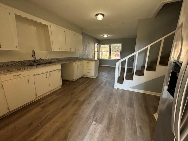 kitchen featuring light stone counters, sink, white cabinets, and dark hardwood / wood-style floors