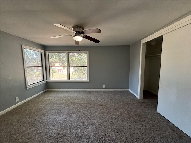 unfurnished bedroom with ceiling fan, a closet, and dark colored carpet