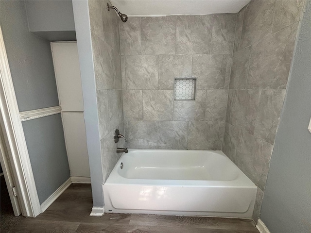 bathroom featuring tiled shower / bath combo and wood-type flooring