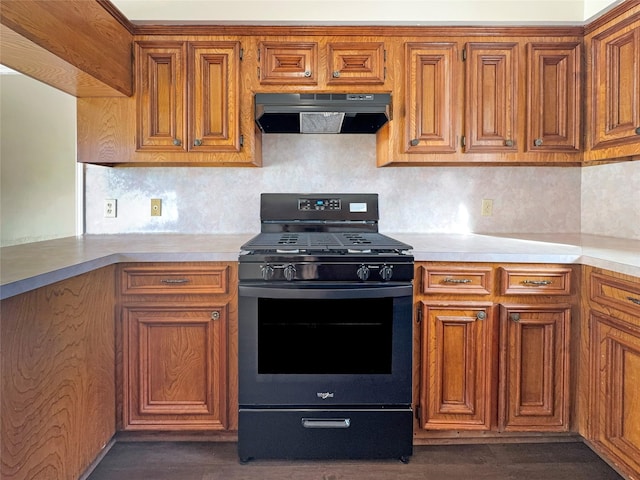 kitchen with black gas stove, tasteful backsplash, and dark wood-type flooring