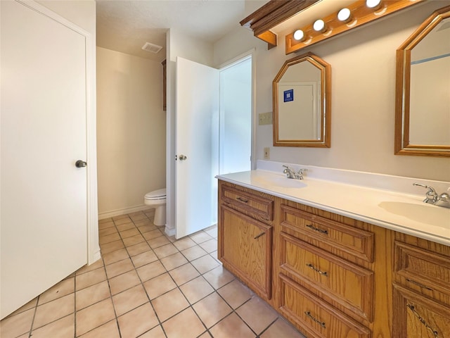 bathroom featuring tile patterned flooring, vanity, and toilet