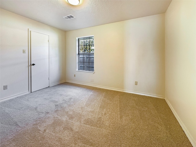 carpeted empty room with a textured ceiling