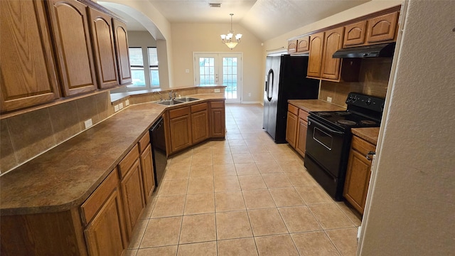 kitchen featuring vaulted ceiling, sink, black appliances, pendant lighting, and light tile patterned floors