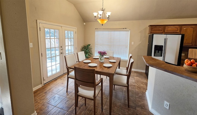 dining room featuring french doors, a chandelier, and vaulted ceiling