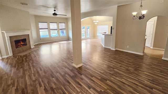 unfurnished living room with a fireplace, dark hardwood / wood-style floors, plenty of natural light, and ceiling fan