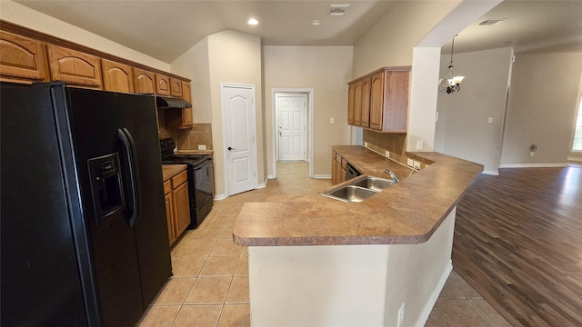 kitchen featuring black appliances, backsplash, light tile patterned floors, and sink