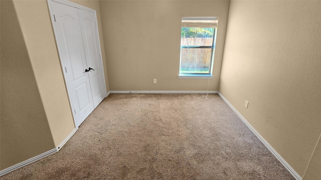 unfurnished bedroom featuring light colored carpet and a closet