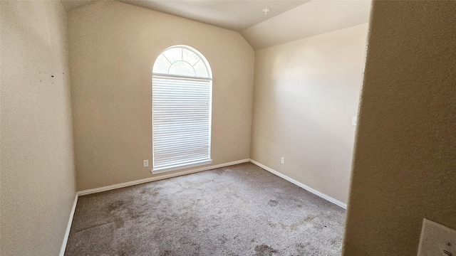 unfurnished room featuring carpet floors and lofted ceiling