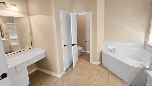 bathroom featuring tile patterned floors, a bathtub, vanity, and toilet