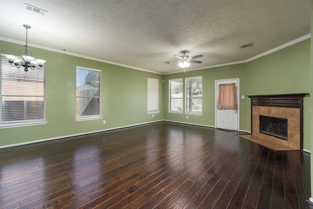 unfurnished living room with ceiling fan with notable chandelier, dark hardwood / wood-style floors, ornamental molding, a textured ceiling, and a fireplace