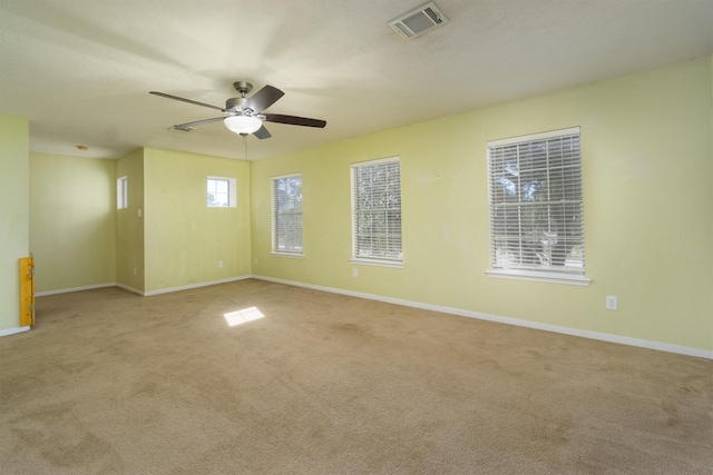 empty room featuring ceiling fan and light carpet