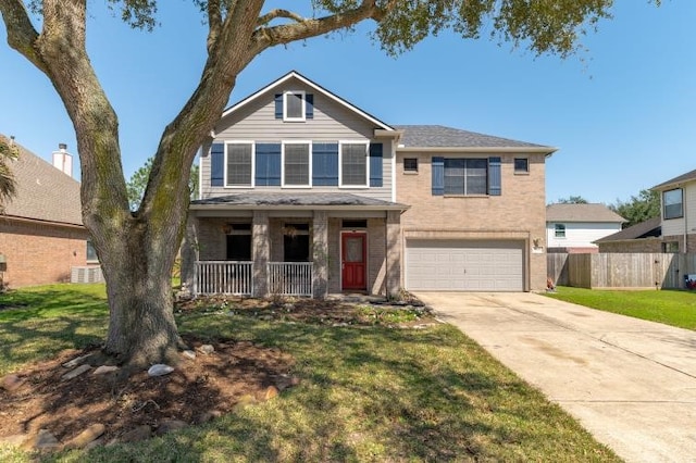 view of front of property with covered porch, a garage, fence, concrete driveway, and a front lawn