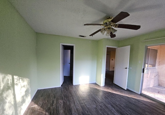 unfurnished bedroom featuring ceiling fan, dark wood-type flooring, and a textured ceiling