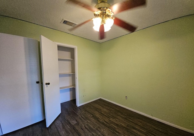 unfurnished bedroom featuring a textured ceiling, ceiling fan, and dark wood-type flooring