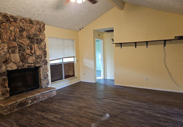 unfurnished living room with a textured ceiling, ceiling fan, dark wood-type flooring, a fireplace, and vaulted ceiling with beams