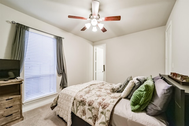 bedroom with light carpet, multiple windows, and ceiling fan