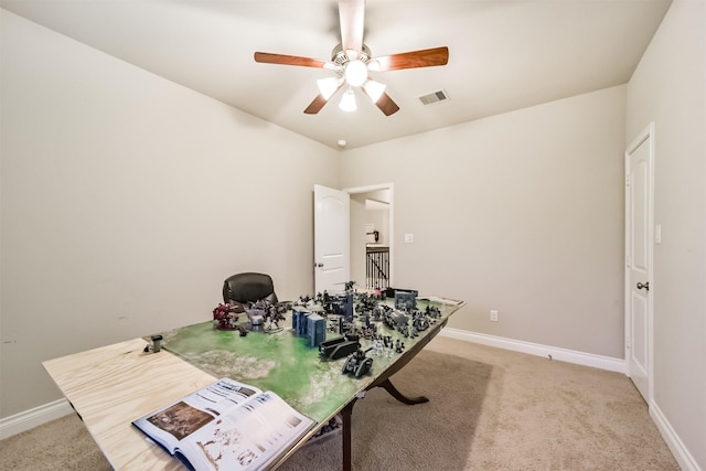 carpeted home office with ceiling fan