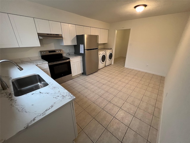 kitchen featuring white cabinetry, sink, stainless steel appliances, washing machine and dryer, and light stone counters