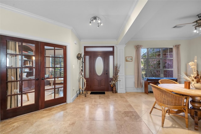 foyer entrance featuring ceiling fan, ornamental molding, and french doors