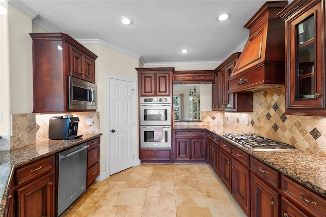 kitchen featuring crown molding, stainless steel appliances, dark stone counters, and tasteful backsplash