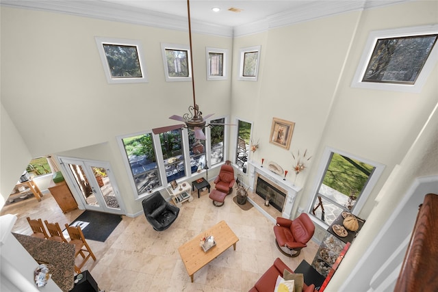 tiled living room with ceiling fan, french doors, crown molding, and a high ceiling