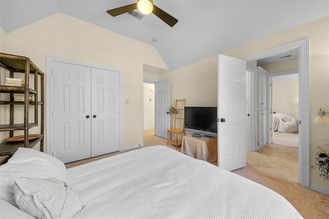 carpeted bedroom featuring a closet, vaulted ceiling, and ceiling fan