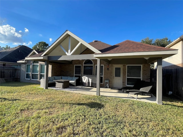 rear view of property with a yard, an outdoor hangout area, and a patio