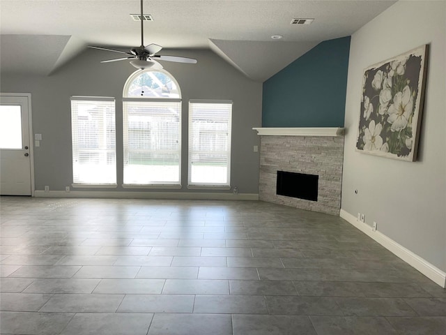 unfurnished living room with ceiling fan, tile patterned floors, lofted ceiling, and a fireplace