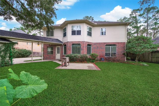 rear view of house featuring a yard and a patio