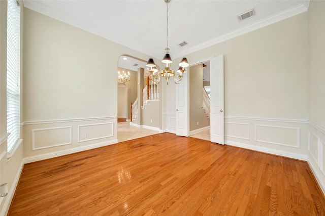 unfurnished dining area with a chandelier, hardwood / wood-style floors, and ornamental molding