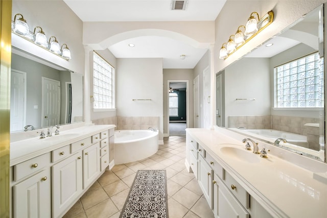 bathroom featuring tile patterned floors, vanity, a bathing tub, and a wealth of natural light