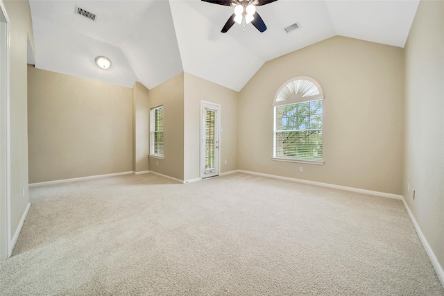 spare room featuring ceiling fan, light colored carpet, and vaulted ceiling