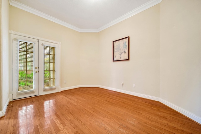 spare room featuring light wood-type flooring and crown molding