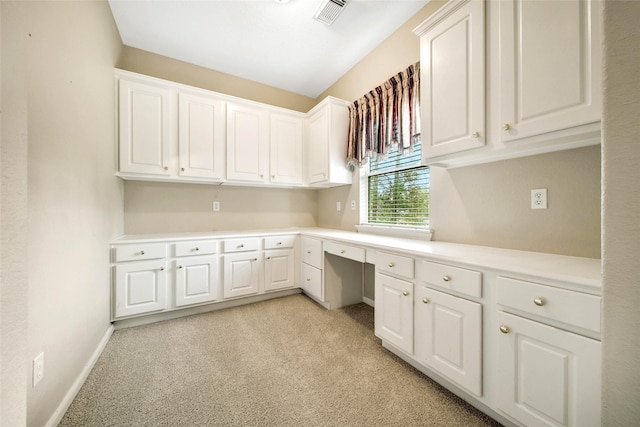 unfurnished office with built in desk and light colored carpet