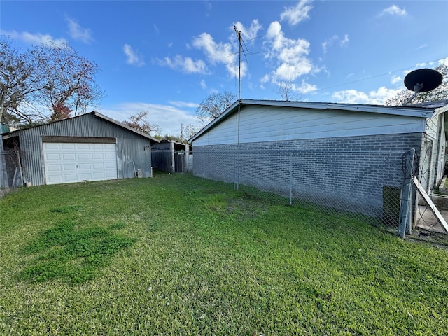 view of yard featuring a garage and an outbuilding