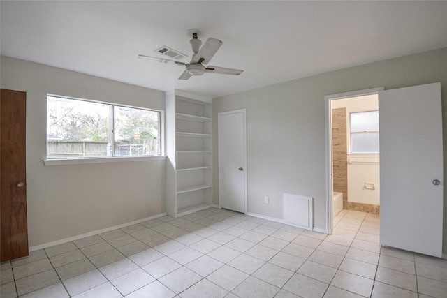 unfurnished bedroom featuring ceiling fan, light tile patterned floors, and ensuite bathroom