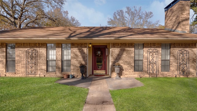 view of exterior entry featuring a yard