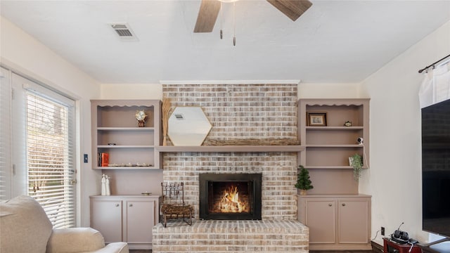 living room with ceiling fan and a brick fireplace