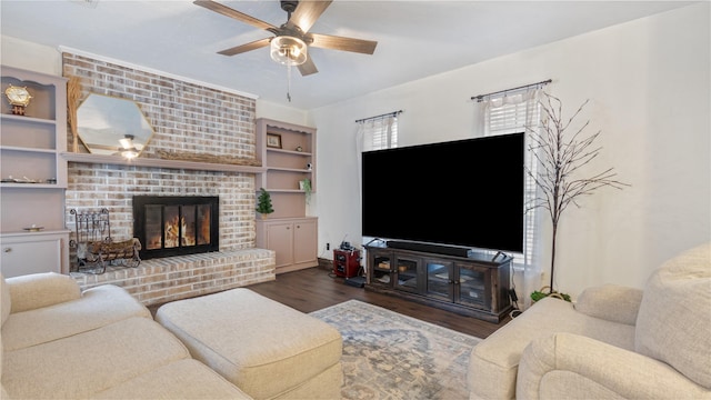 living room featuring ceiling fan, dark hardwood / wood-style flooring, and a brick fireplace