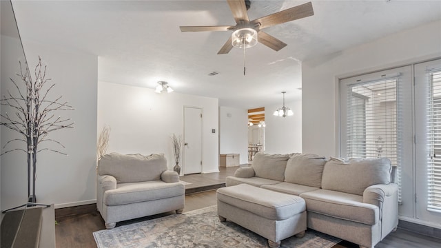 living room featuring ceiling fan with notable chandelier, dark hardwood / wood-style floors, and plenty of natural light