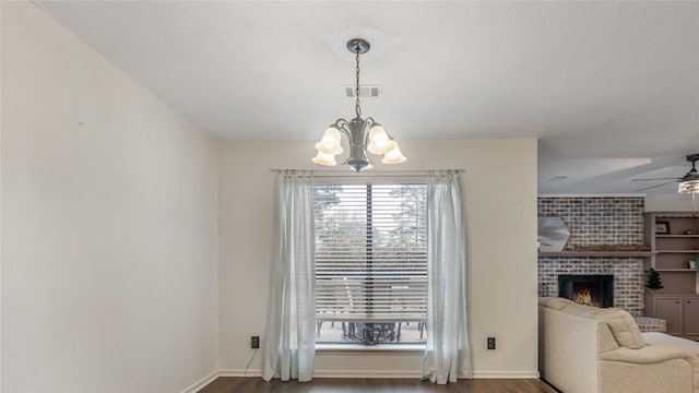 dining room with a fireplace, ceiling fan with notable chandelier, and dark hardwood / wood-style floors