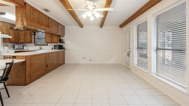 kitchen with kitchen peninsula, beam ceiling, ceiling fan, and sink